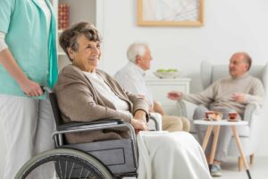 Older adults unpacking boxes together in a cozy, light-filled room while chatting and laughing.