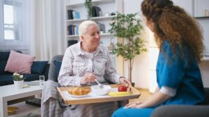 Older resident speaking with a family member in a bright assisted living common room