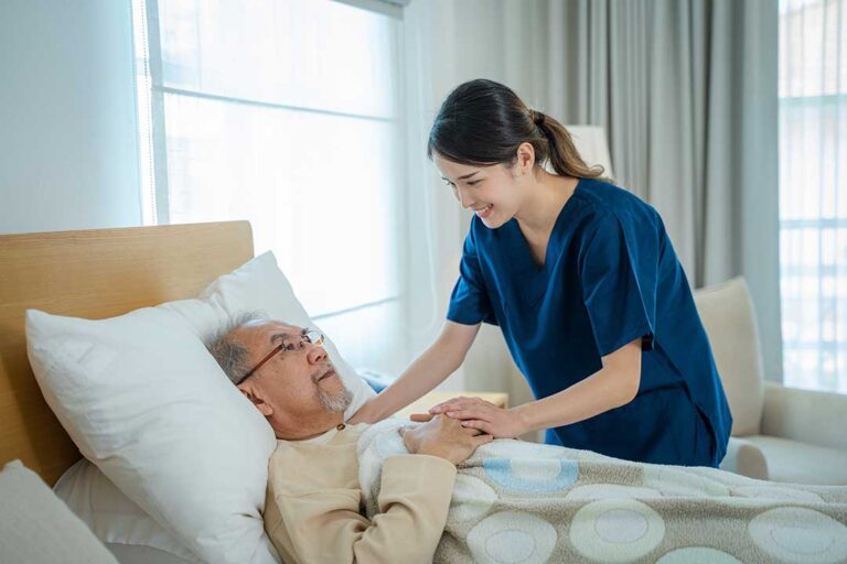 Resident and staff member calmly discussing a concern at a table in an assisted living common room
